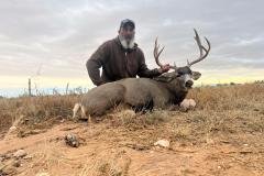Hunter with trophy mule deer buck during a guided New Mexico hunt